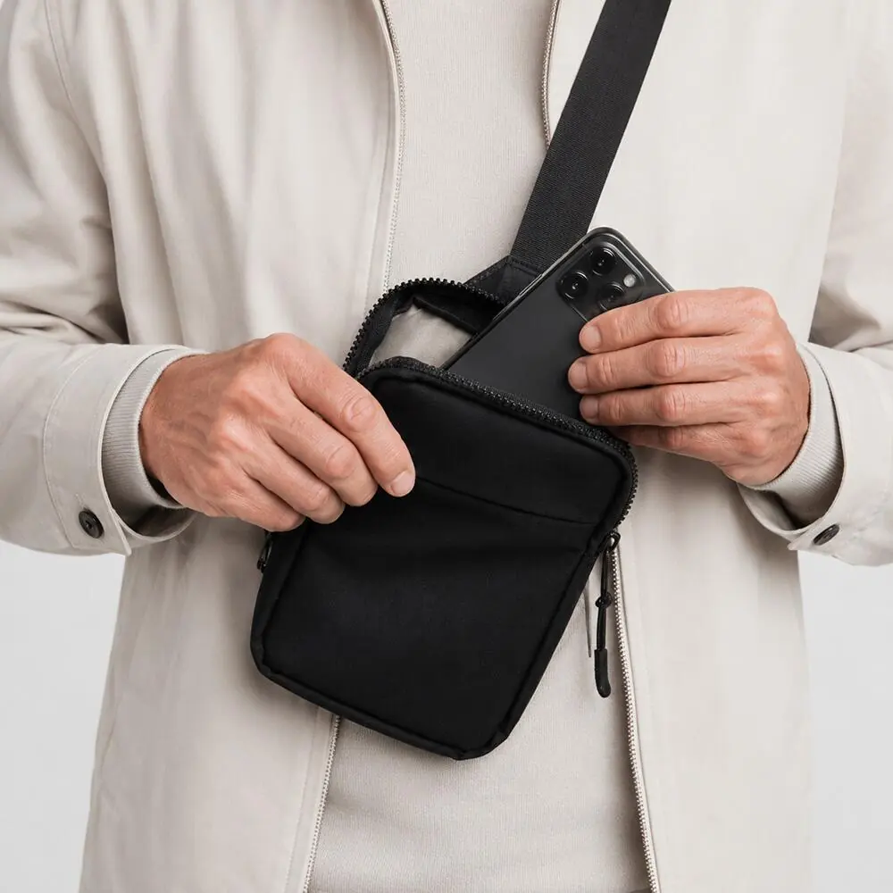 SteelGuard PRO worn across the chest, phone being placed in the main pocket
